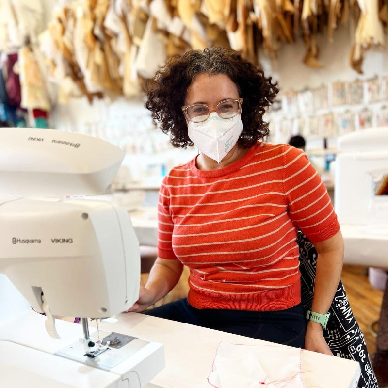 lady at sewing machine with orange striped shirt