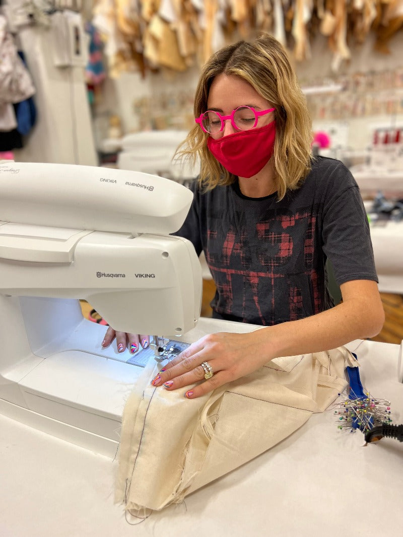 girl in pink glasses sewing