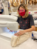 girl in pink glasses sewing