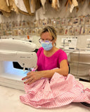 lady in pink shift at sewing machine